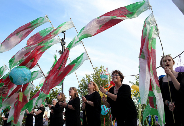 Members of the KEFAS Choir from Denmark wave salmon wind socks during the May 12 General Conference Climate Vigil at Oregon Convention Center Plaza in Portland. Photo by Kathleen Barry, UMNS.