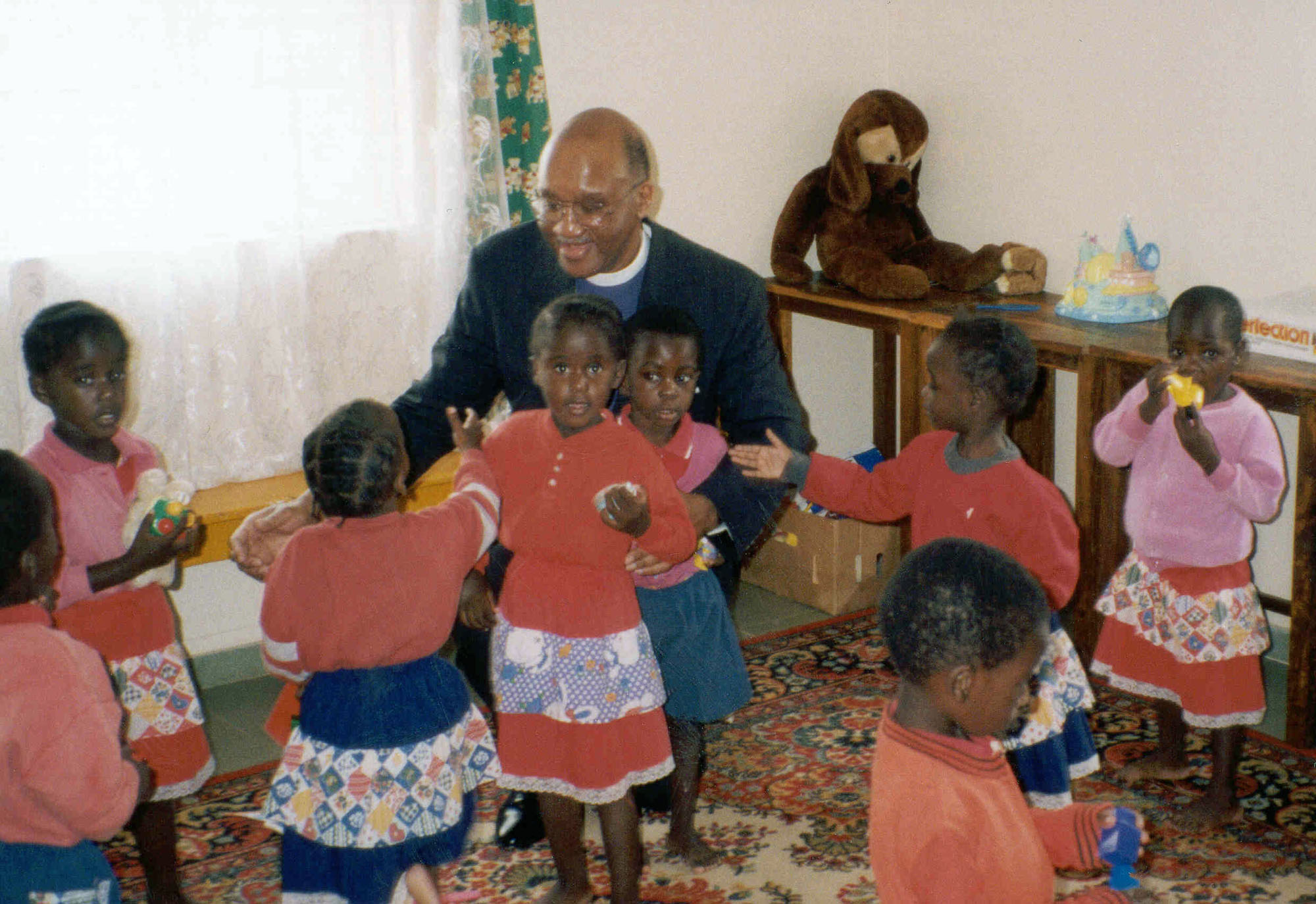United Methodist Bishop Felton May plays with children at a Zambian orphanage in 1999 during a trip in support of a Presidential Mission on Children and AIDS. The trip