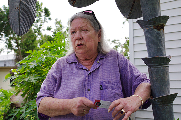 Niki Graham leans against an aluminum palm tree, the only tree still standing on her Goodland, Florida, property. Photo by Gustavo Vasquez, UMNS.