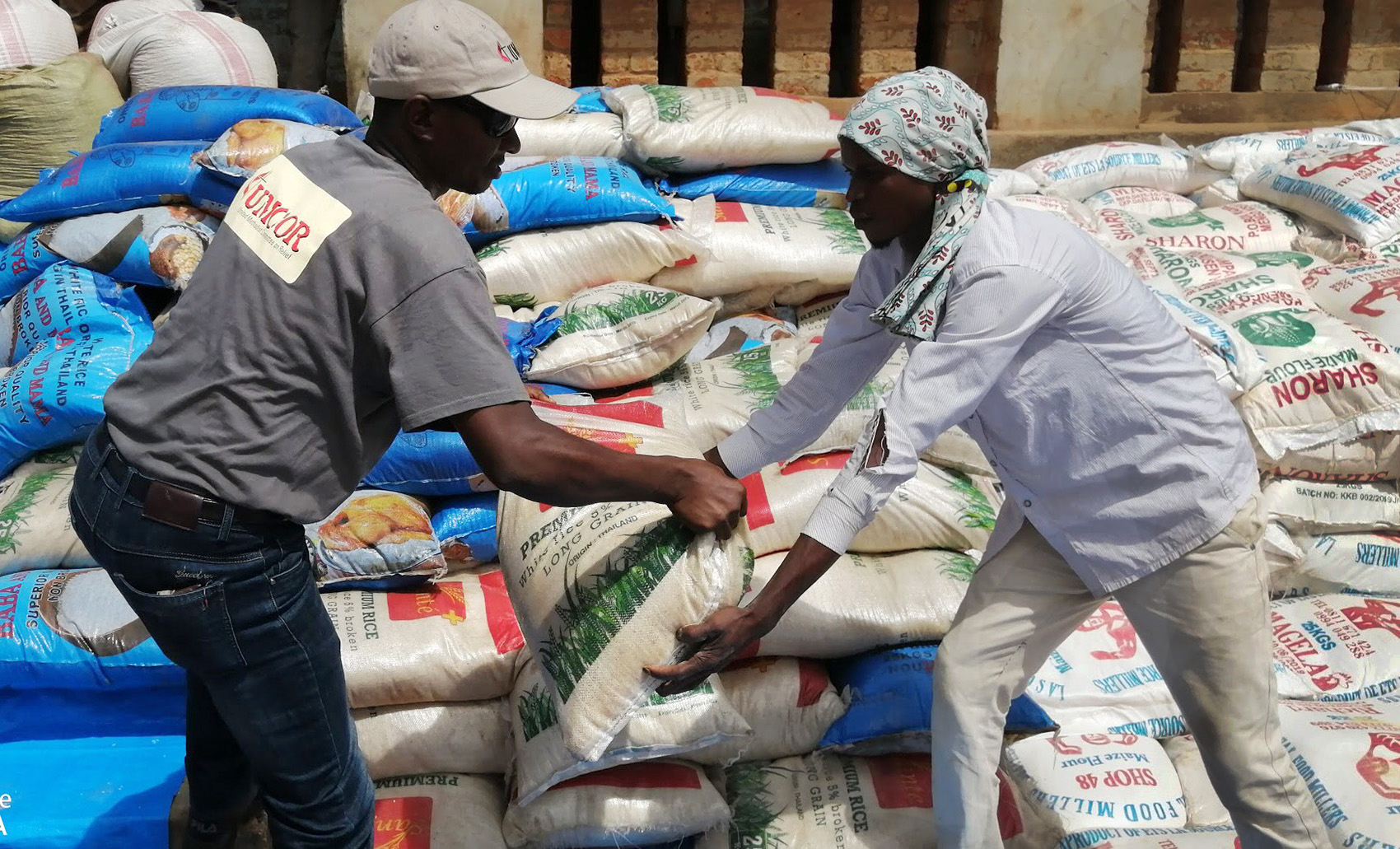 Jean Tshomba, coordinator of UMCOR's disaster management office in Eastern Congo, hands over a bag of flour to one of the beneficiaries during the distribution of food in the Lubutu ecclesiastical district at the end of November 2019. The United Methodist Committee on Relief provided humanitarian assistance to war-displaced people in the region. Photo courtesy of UMCOR Disaster Management Office, East Congo. 