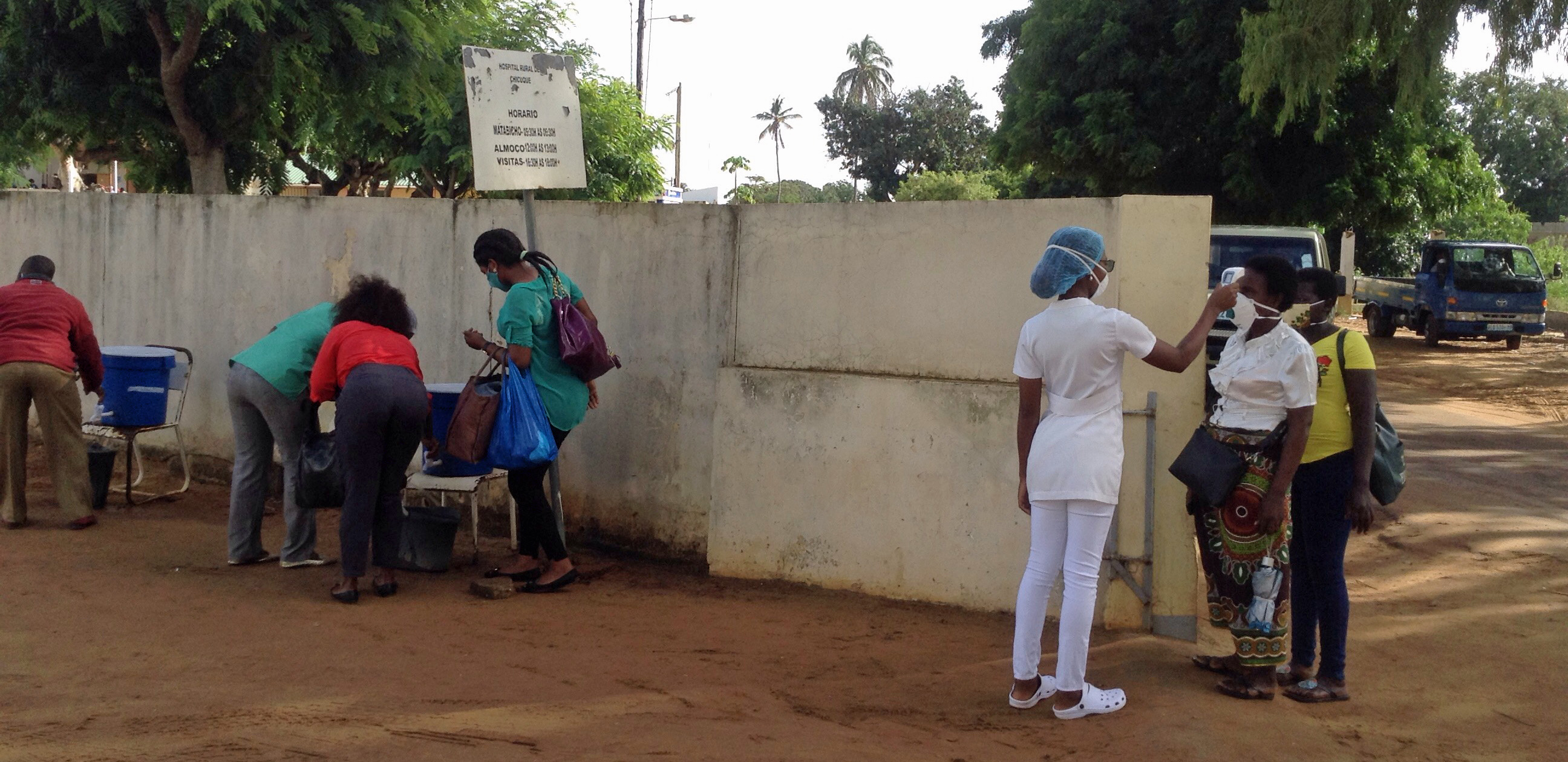 Utentes do Hospital Rural de Chicuque, sendo testados a temperatura na entrada principal do hospital e depois recomendados a lavarem as mãos. Chicuque, foto de António Wilson.