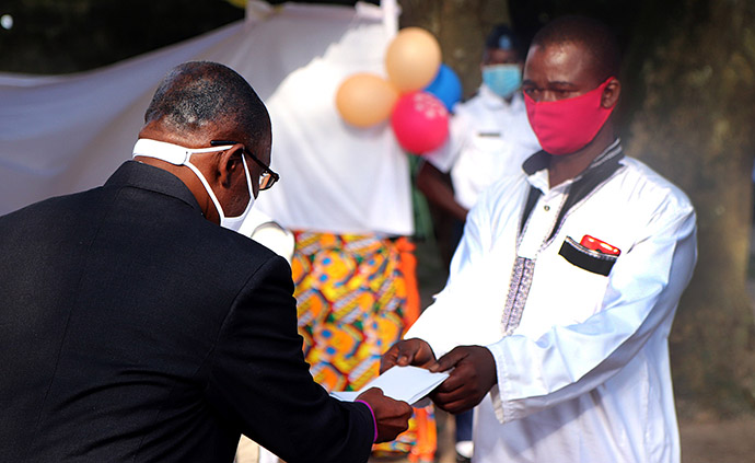 L’Evêque Benjamin Boni remet une enveloppe d'argent liquide à Seydou Bakayoko, qui a perdu cinq proches dans les inondations à Abidjan. Chaque famille endeuillée a reçu 100 dollars pour chaque personne décédée au cours d'une cérémonie spéciale qui s'est tenue à Anyama, en Côte d'Ivoire. Photo de Isaac Broune, UM News.