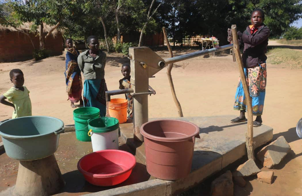 Veronika Mwale (right) pumps water from a borehole in Thako village in Mchinji, Malawai. The borehole, which supplies water for three villages, was built through a partnership between Ankeny United Methodist Church in Ankeny, Iowa, and the Malawi Provisional Conference. Photo by Francis Nkhoma, UM News.