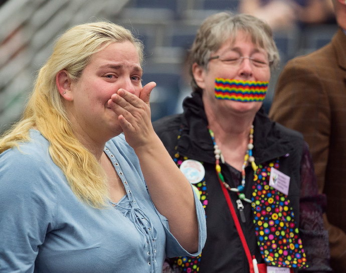 Des partisans de l’égalité des personnes LGBTQ dans la vie de l’Église Méthodiste Unie, certains avec la bouche scotchée, se tiennent à l’extérieur de la Conférence Générale 2016 de l’Église Méthodiste Unie à Portland, Oregon, pour symboliser la façon dont les personnes LBGTQ se sentent réduites au silence par l’Église. Photo d’archives de Mike DuBose, UM News. 
