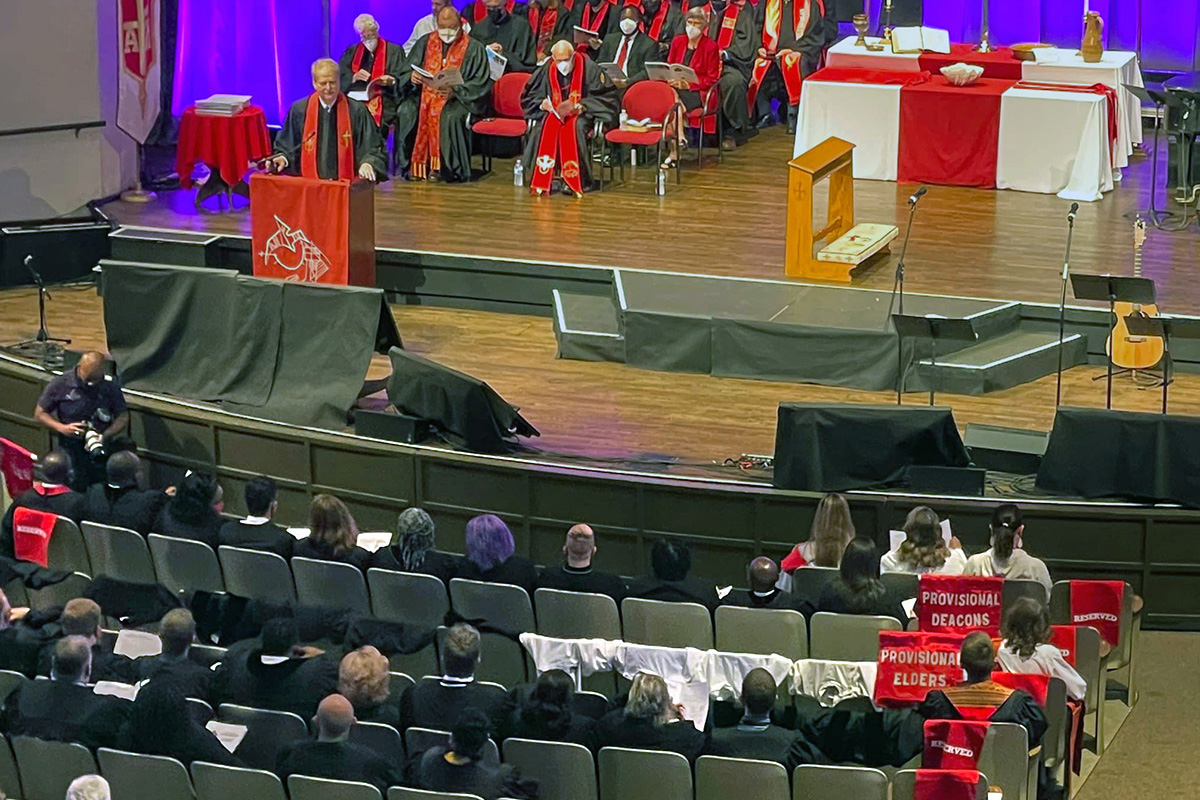 Las sillas cubiertas simbolizan que los/as candidatos/as de la Conferencia Anual de Florida para membresía provisional, un paso importante hacia la ordenación como anciano/a o diácono/a, no lograron la aprobación de la sesión del clero de la conferencia. La controvertida decisión tomada durante la reunión de la conferencia en Lakeland, Florida, ilustró la división denominacional sobre la inclusión LGBTQ. La decisión también alteró el servicio de clausura del 11 de junio, donde se comisionarían los 16. Foto de Esther Rodríguez vía Facebook.