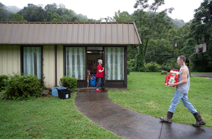Austin Herald unloads relief supplies donated for flood survivors at United Methodist Mountain Mission. Herald is an employee of the center. Holding the door is volunteer Debbie Holcomb from Hampton (Ky.) United Methodist Church. Photo by Mike DuBose, UM News.