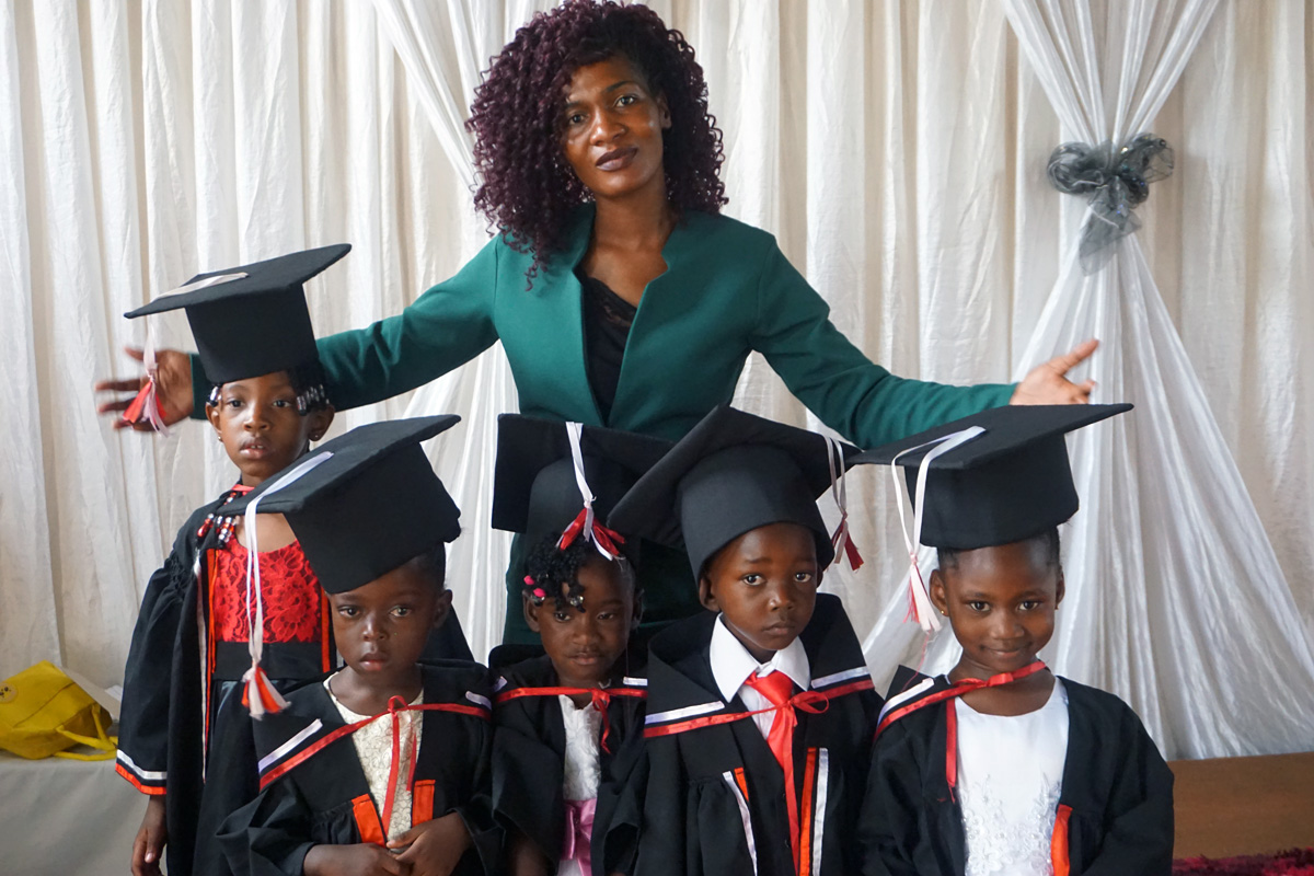 Pauline Violet Mushati posa con graduados de la Escuela Cristiana Barrington de la Iglesia Metodista Unida en Harare, Zimbabue. Mushati es maestra en la escuela que abrió sus puertas en 2021. Es una de las dos escuelas privadas de vanguardia en Harare fundadas por La Iglesia Metodista Unida en Zimbabue. Foto de Kudzai Chingwe, Noticias MU.