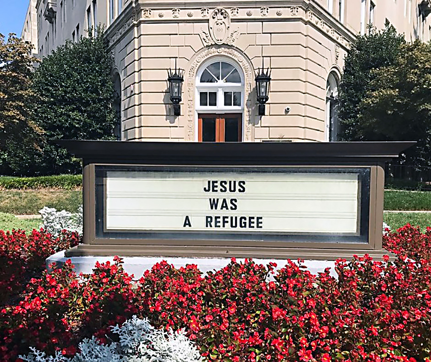 A foto de arquivo mostra um outdoor em frente ao Edifício Metodista Unido, sede da Junta Geral de Igreja e Sociedade (GBCS) localizado diagonalmente ao Congresso dos Estados Unidos, onde está escrito “Jesus foi um refugiado”, segundo o que diz o evangelho de Mateus 2:1-15 descreve. Foto cortesia de GBSC.