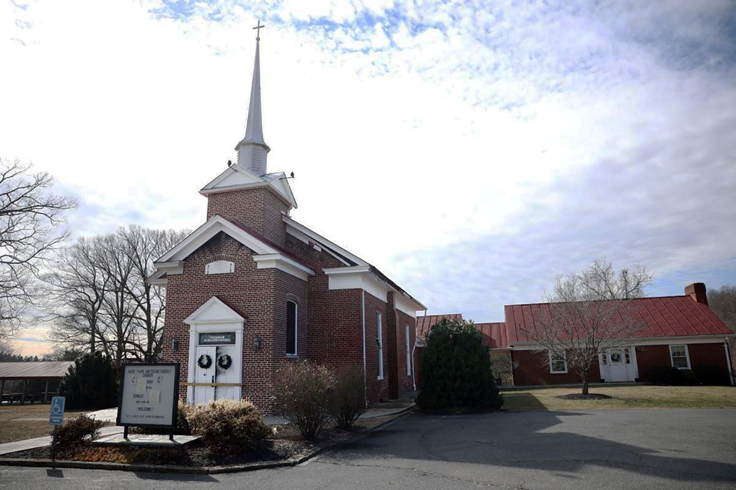 Las puertas del santuario de la Iglesia Metodista Unida (IMU) Rose Park están carbonizadas y bloqueadas luego del incendio ocurrido la semana pasada. Las notas pegadas en el letrero al frente del edificio, informan que nadie resultó herido/a y ordenaban a los/as visitantes de la iglesia que asistieran al servicio en la IMU de Madison. En nota separada se cita Isaías 43: 2-3a que hace referencia a caminar a través del fuego y no ser quemado/a. Foto Gracie Hart Brooks, cortesía de The Daily Progress.