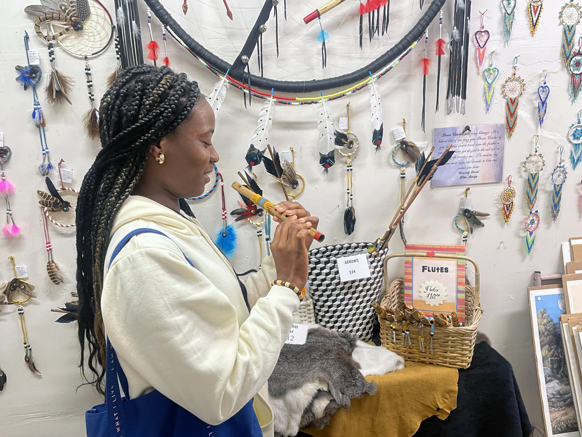 Ebiye Seimode, a student at the Boston University School of Theology and participant in the Oklahoma Indian Missionary Conference Immersion Experience, samples a flute for sale at Oklahoma Native Art & Jewelry on March 9, 2023, in Oklahoma City. Photo by Jim Patterson, UM News.