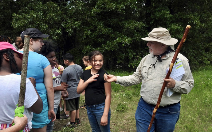 Master naturalist Ronald Carson shares an insect discovery with a wary student from Justiss Elementary of Paris, Texas. The nonprofit Cultiv8 Community, founded by the Rev. Rob Spencer, hosted Justiss kids at Methodist Camp on Pat Mayse Lake, on May 19. Photo by Sam Hodges, UM News.