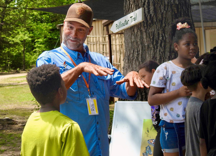 The Rev. Rob Spencer chats with a young camper on May 19 at the Methodist Camp on Pat Mayse Lake, near Paris, Texas. Spencer, a United Methodist elder, founded Cultiv8 Community, a nonprofit that gets local schoolchildren out into nature. Photo by Sam Hodges, UM News.
