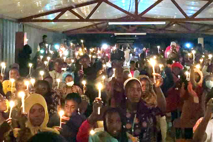 Jovens do Oeste de Angola seguram 71 velas para assinalar o 71º aniversário do grupo de jovens Juventude Metodista da Conferência Oeste de Angola. A noite das velas foi um dos destaques de um acampamento de seis dias para jovens de 12 a 25 anos dos 12 distritos da conferência. Foto cortesia da Juventude Metodista.