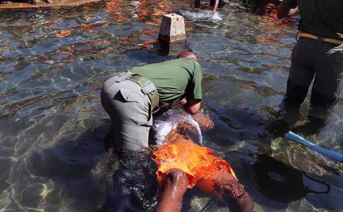O capelão Jefat Zhou imerge um recluso durante um evento de batismo realizado pela Igreja Metodista Unida na Prisão de Segurança Máxima de Chikurubi em Harare, Zimbabué, no dia 28 de julho. Centenas de reclusos foram batizados como parte do ministério de extensão da igreja na prisão. Foto de Prudence Choto, Prisão de Segurança Máxima de Chikurubi.