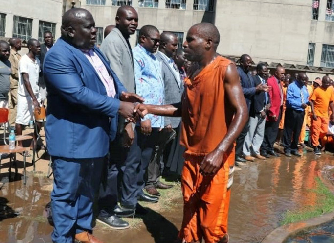 Os líderes da igreja de Harare East, os Revs. Oscar Nyasha Mukahanana (à esquerda), David Mupaya e John Makaniko parabenizam um preso que foi batizado em 28 de julho na Prisão de Segurança Máxima de Chikurubi em Harare, Zimbábue. Mukahanana, um superintendente distrital, encorajou os reclusos a aceitarem Jesus Cristo como seu Salvador, independentemente da gravidade dos seus crimes. Foto de Prudence Choto, Prisão de Segurança Máxima de Chikurubi.