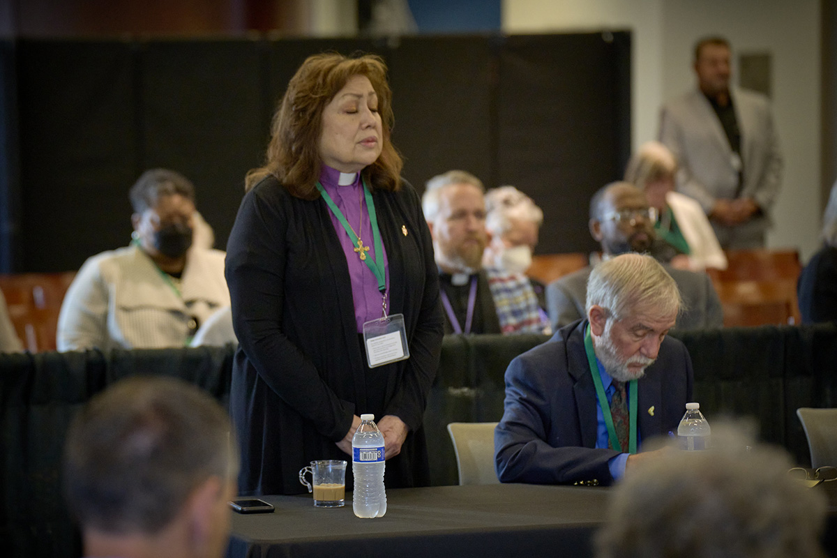 United Methodist Bishop Minerva G. Carcaño stands as the presiding bishop reads the jury verdict on Sept. 22, the fourth day of her church trial in Glenview, Ill. Carcaño was found not guilty on all four charges against her. At right is the Rev. Scott Campbell, who represented Carcaño during the trial. Photo by Paul Jeffrey, UM News.