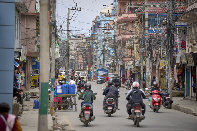 Motorcyclists traverse a street in Lalitpur, Nepal, May 25. The Rev. Jeewan Lama, pastor of Hebron United Methodist Church, says Christianity spreads more easily among the poor, who find an acceptance in the church not offered to them in the larger Nepalese society. Photo by Paul Jeffrey, UM News.