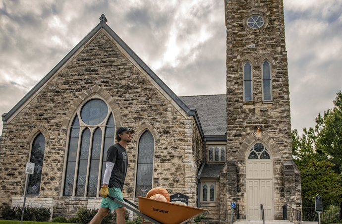 First United Methodist Church in Georgetown, Texas, is the backdrop for a man wheeling pumpkins. The church is in its 26th year of having a fall pumpkin patch. Photo by Andy Sharp.