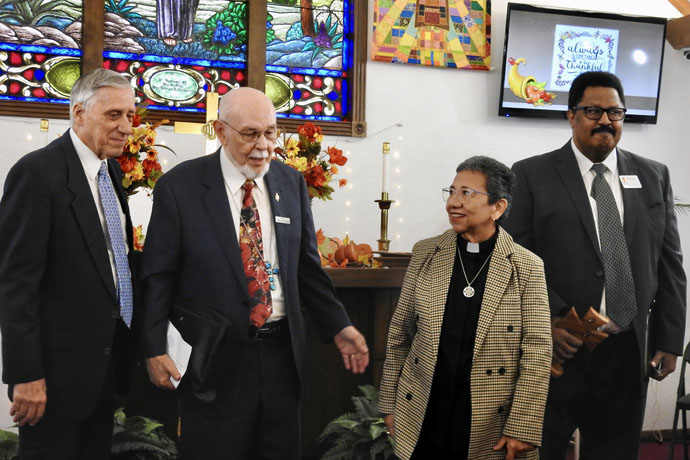 The Rev. Ron Welborn, Retired Bishop Joel Martinez, the Rev. Nohemí Ramirez and the Rev. Marcus Freeman, a Rio Texas Conference district superintendent, begin to exit the La Trinidad United Methodist Church after worship on Nov. 19. La Trinidad, a historic Hispanic church in Seguin, Texas, has provided meeting space and crucial support to Walnut Springs United Methodist, a new church formed of people who stayed United Methodist after their Seguin church disaffiliated. Welborn leads the new group and Ramirez leads La Trinidad. Photo by Sam Hodges, UM News.