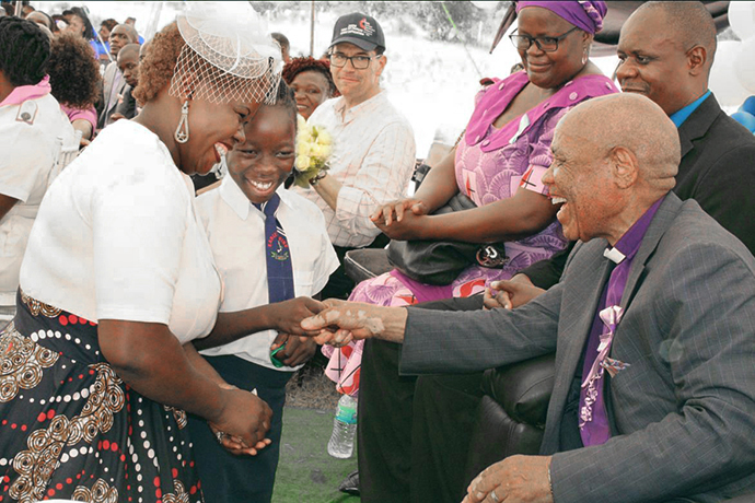 Naledi Mudzedze (au centre) et sa mère saluent l'évêque Eben K. Nhiwatiwa lors de la cérémonie d'inauguration de la nouvelle clinique de la mission Munyarari à Munyarari, au Zimbabwe. Mme Mudzedze a déclaré par la suite : "Je n'avais jamais salué mon évêque auparavant". Photo par Kudzai Chingwe, UM News.