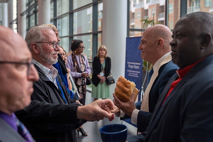 O Bispo John Schol, que lidera as conferências da Grande Nova Jérsia e da Pensilvânia Oriental, e o Bispo da Área da Nigéria John Wesley Yohanna servem os elementos durante o Serviço de Comunhão da Capela de Oração do Cenáculo na Conferência Geral Metodista Unida em Charlotte, CN. Foto de James Lee, Conferência da Grande Nova Jérsia.