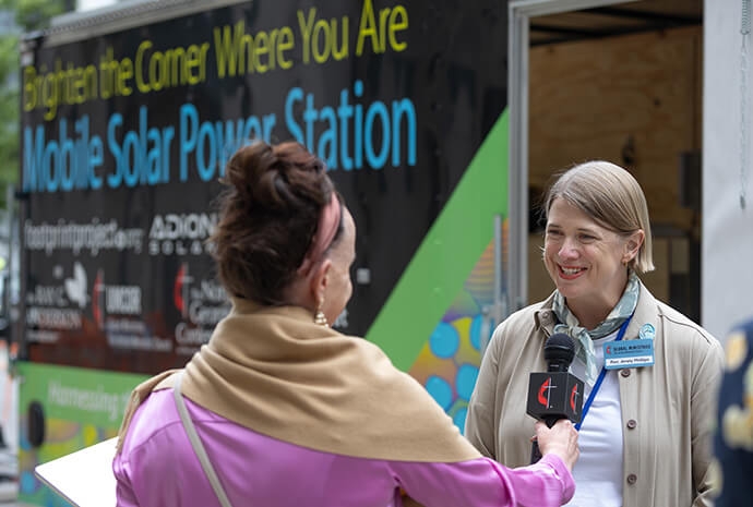 The Rev. Jenny Phillips is interviewed in front of a Mobile Solar Power Station used to provide electricity in natural disaster situations. The power station is parked outside the United Methodist General Conference in Charlotte, N.C. Photo by Mike DuBose, UM News.