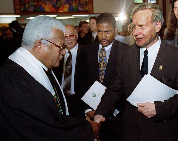 United Methodist pastor the Rev. James M. Lawson Jr. (left) speaks with attorney William Pepper following a funeral service for James Earl Ray, convicted killer of the Rev. Martin Luther King Jr., in Nashville, Tenn., in 1998. In the background are Ray's brother, Jerry Ray (left), and King’s nephew, Isaac Farris Jr. File photo by Mike DuBose, UM News.