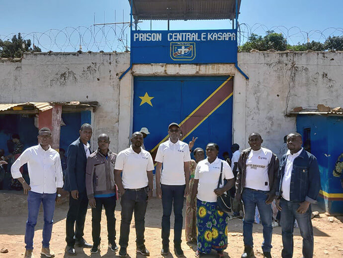 The Disaster Management Office team for the South Congo Episcopal Area poses in front of Kasapa Central Prison with prison staff and volunteers. Kasapa, home to some 2,679 prisoners, is near Lubumbashi, Congo. Photo by Christian Kasweka, UM News.