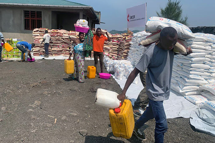 People living in a camp for displaced people carry supplies from a distribution site in Goma, Congo, after receiving food assistance from The United Methodist Church. With funding from the United Methodist Committee on Relief, the church distributed over 198 tons of food and non-food items to displaced families in the Masisi region. Photo by Chadrack Tambwe Londe, UM News.