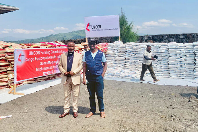 Jean Tshomba, coordinator of UMCOR’s disaster management office in eastern Congo, and the Rev. Kasongo Numbize, a delegate to the Kivu Annual Conference, pose for a photo before helping to distribute food and non-food items at a distribution site for displaced persons in Goma, Congo. Photo Chadrack Tambwe Londe, UM News.