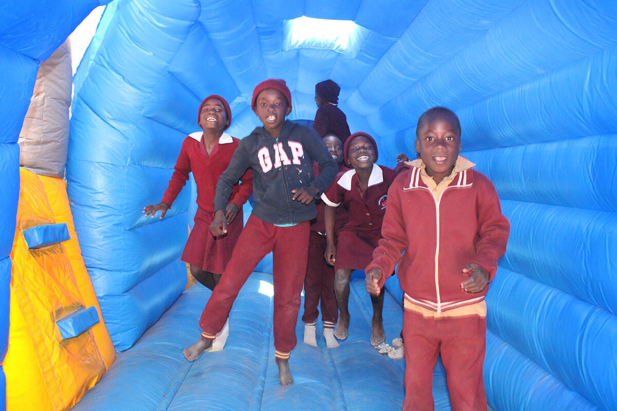 Des élèves de l'École Primaire Méthodiste Unie Hanwa à Macheke, au Zimbabwe, jouent dans un avion gonflable lors d'une journée d'amusement pour enfants parrainée par Zimbabwe Volunteers in Mission, un ministère de la Conférence de Baltimore-Washington de la dénomination. Photo par Kudzai Chingwe, UM News.