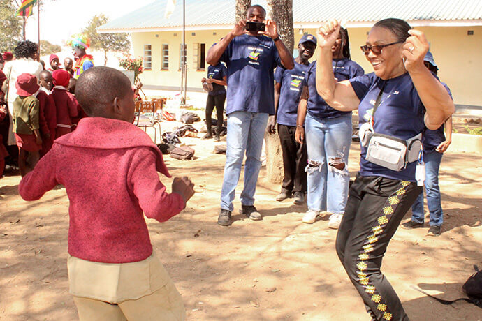 L'étudiant Tanatswa Mutandwa (à gauche) danse avec la Révérende Angela Kittrell de l'équipe des Volontaires en Mission du Zimbabwe. Photo par Kudzai Chingwe, UM News.