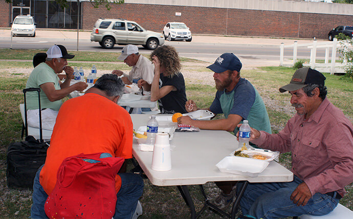 People sit for a meal at an Ice Angels serving site near downtown Oklahoma City. Volunteers, including United Methodists, serve meals to the community every Wednesday. Neighborhood Services Organization, part of the Ice Angels network, provides the space for the weekly lunches. Photo by Boyce Bowdon, UM News.