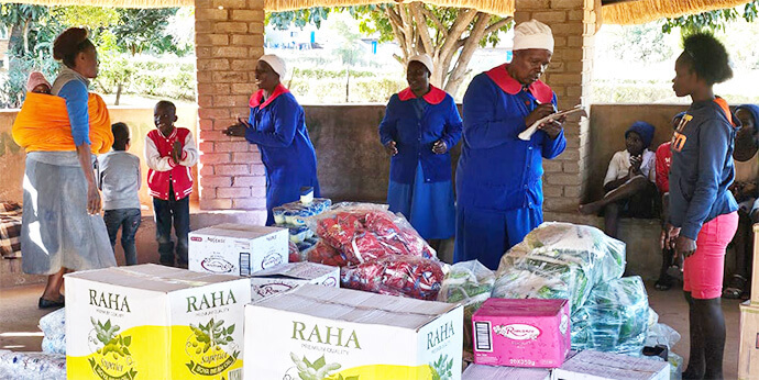 Ruwadzano Rwe United Methodist Church members and Fairfield Children’s Home staff oversee the distribution of food hampers for children at the United Methodist-related orphanage in Mutare, Zimbabwe. The Class of 81 Charitable Foundation, led by former students of Hartzell High School, donated the supplies. Photo by Tafadzwa Gumbochuma.