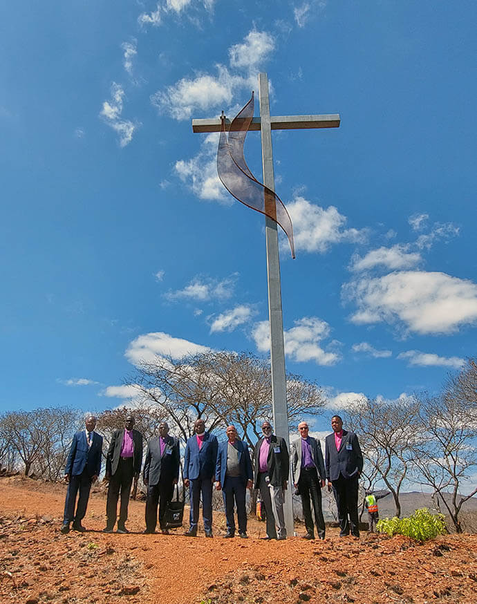 United Methodist bishops stand at the foot of a cross that overlooks Africa University Sept. 4 in Mutare, Zimbabwe. The bishops took time to pray and reflect on the mountain during the annual Africa Colleges of Bishops learning retreat held at the United Methodist university from Sept 2-5. Photo courtesy of Ndzulo Tueche, General Council of Finance and Administration.