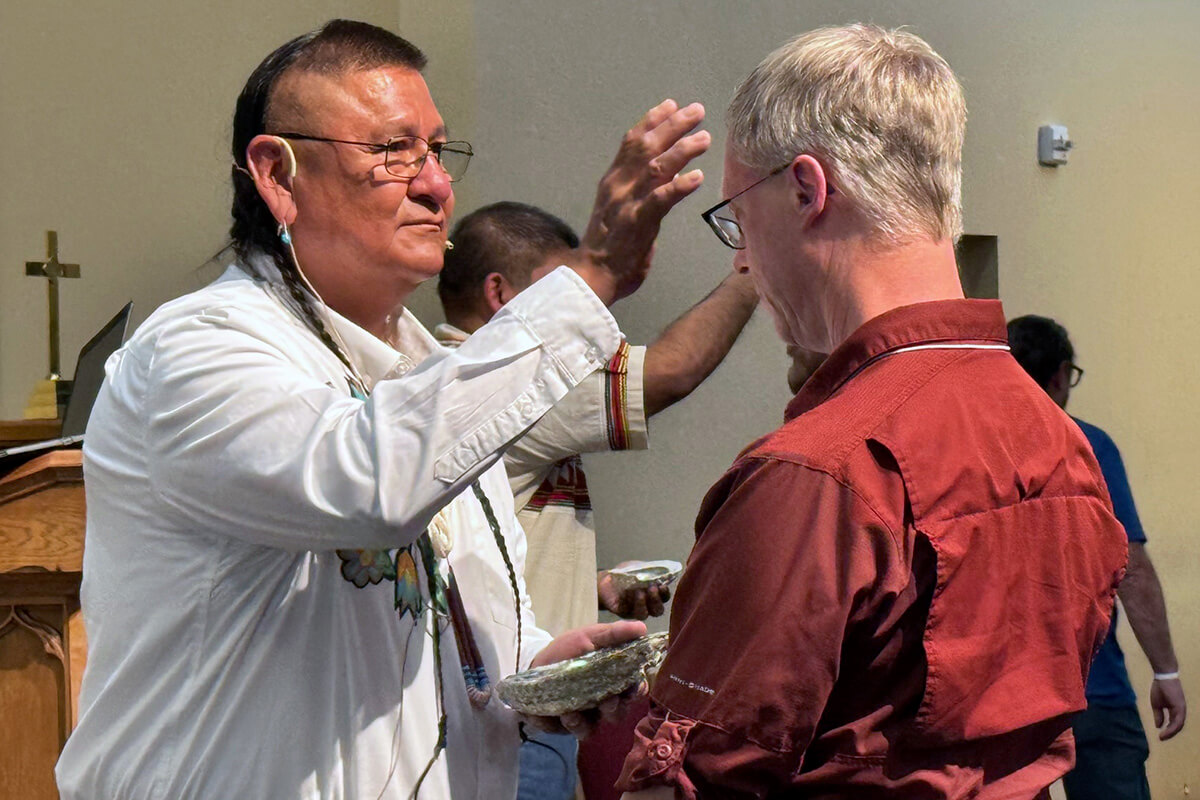 The Rev. Calvin Hill, a Navajo holy man and pastor at First United Methodist Church in Newcastle, Wyo., puts cedar ashes on Doug Tzan, assistant dean at Wesley Theological Seminary, in a calling your name ceremony Sept. 11 during the 10th Historical Convocation at Bozeman United Methodist Church in Bozeman, Mont. The convocation featured a detailed report on The United Methodist Church’s involvement with U.S. boarding schools for Native American children. Photo by the Rev. Jeremy Smith.