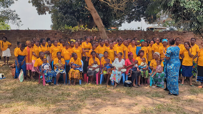 A Dra. Marie-Claire Manafundu (de vestido azul), coordenadora do programa de Saúde Materna, Neonatal e Infantil da Igreja Metodista Unida no Congo Leste, fala para um grupo de mulheres sobre os benefícios da amamentação para a saúde durante uma paragem no Centro Mama Lynn da igreja em Kindu, Congo. "Organizámos estas actividades para aumentar a sensibilização, motivar as mães e explicar a importância da amamentação," disse Manafundu. Foto de Chadrack Tambwe Londe, Notícias da MU.