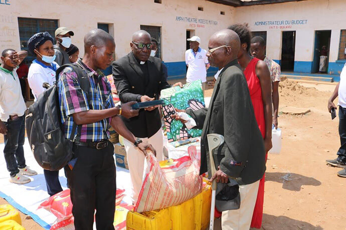 Le Révérend Clément Kingombe, délégué de l'évêque Gabriel Unda Yemba à la Conférence annuelle du Kivu, distribue des vivres et des articles non alimentaires aux survivants des incendies dans la ville de Bukavu, au Congo. Photo par Philippe Kituka Lolonga, UM News.