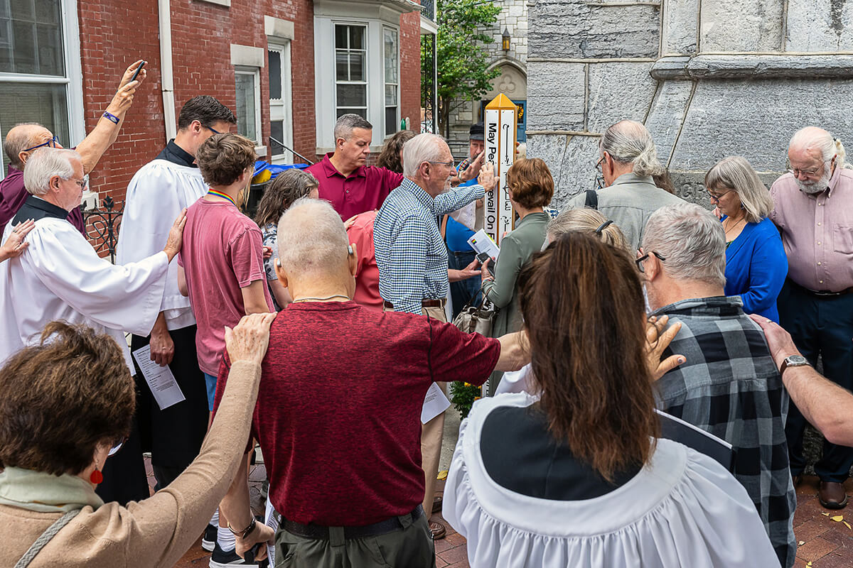 Members of Grace United Methodist Church in Harrisburg, Pa., gather around their “Peace Pole,” installed to commemorate the Sept. 21 International Day of Peace and also in recognition of the charged political climate in the U.S. because of the presidential election. Photo courtesy of Grace United Methodist Church.