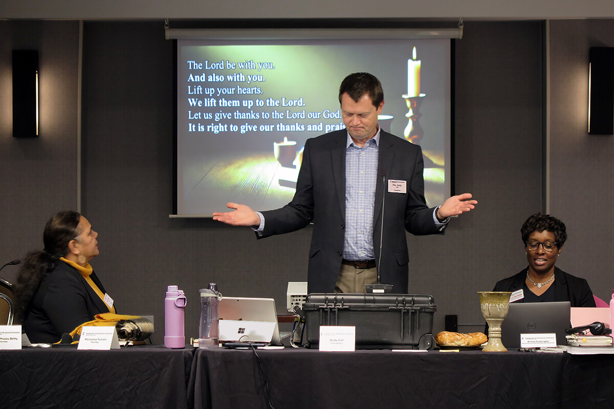O Rev. Andy Call, presidente da comissão da Conferência Geral, ajuda a liderar a Sagrada Comunhão durante o culto de abertura em 19 de novembro na reunião da comissão da Conferência Geral em Charlotte, NC. Sentados ao lado de Call estão Monalisa Tui'tahi (à esquerda), vice-presidente da comissão, e a Revda. Aleze M. Fulbright (à direita), a nova secretária da Conferência Geral. Durante a reunião, a comissão começou os preparativos para a próxima reunião da principal assembleia legislativa da Igreja Metodista Unida, programada para 2028. Foto de Heather Hahn, Notícias MU. 