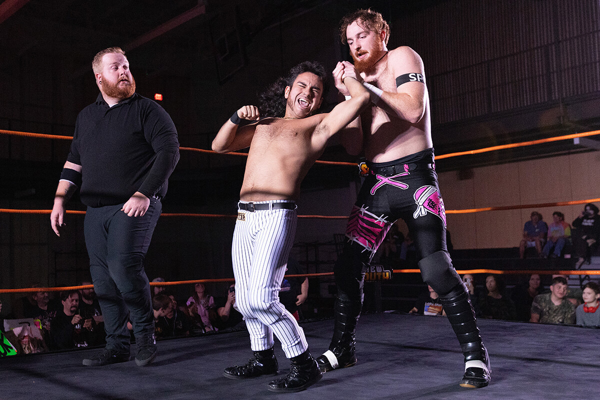 Rolando Pérez, al centro, hace muecas durante un combate de lucha libre con Jamesen Shook en un evento de New South Pro Wrestling celebrado el 2 de noviembre en el Centro de Eventos de Priceville, Alabama. 
