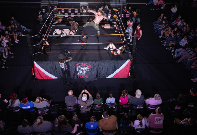 El Rev. Steven Barber anima a los luchadores mientras la acción sale del ring y llega a la pista el 2 de noviembre en el Centro de Eventos de Priceville, Alabama. Barber, pastor de la Iglesia Metodista Unida Neel en Hartselle, Alabama se desempeña como capellán no oficial de la comunidad de lucha libre profesional. 