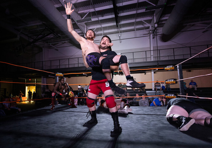 El luchador Negative Lee sostiene en alto a Jake Franklin su compañero de equipo, después de una victoria durante un evento de New South Pro Wrestling celebrado el 2 de noviembre en el Centro de Eventos de Priceville, Alabama. 