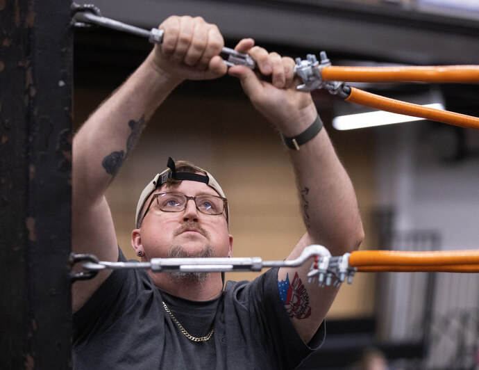 El Rev. Steven Barber ayuda a desmontar el ring de lucha libre después de un combate en el Centro de Eventos de Priceville, Alabama. 