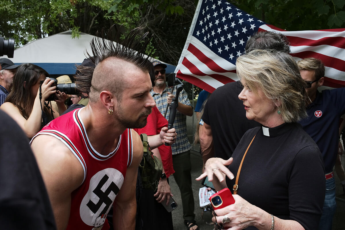 The Rev. Neelley Hicks talks with a neo-Nazi demonstrator outside Nashville Together, a rally in Nashville, Tenn., on July 21. Hicks attended the rally to support a friend who was the subject of anti-Semitic attacks. The neo-Nazi was part of a group holding a counter-demonstration. Photo by Ray di Pietro.