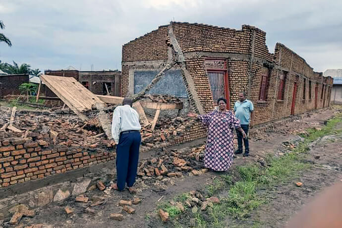 The Rev. Valentine Cimpaye, Bujumbura District superintendent, stands in front of one of the destroyed buildings of the Lycée Technique Mgr. Jean Alfred Ndoricimpa secondary school in Bujumbura, Burundi. The United Methodist school was severely damaged by recent storms. Also pictured are Niyomwungere Juvénal (left), Lycée’s technical director, and Makarakiza Obed (right), district lay leader. Photo by Jerome Ndayisenga, UM News. 