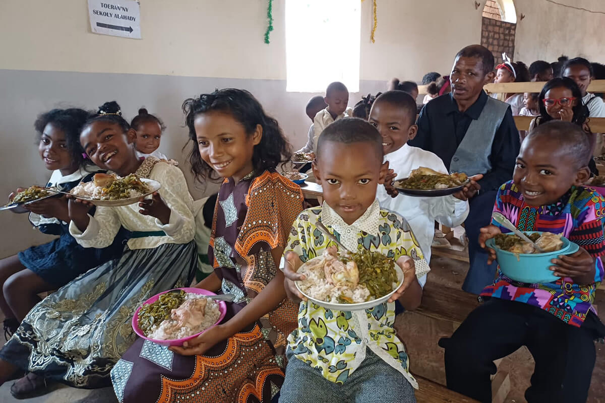 Membros da igreja e da comunidade recebem comida para a Celebração de Natal na IMU de Ambodifasika. Foto de Esdras Rakotoarivony.