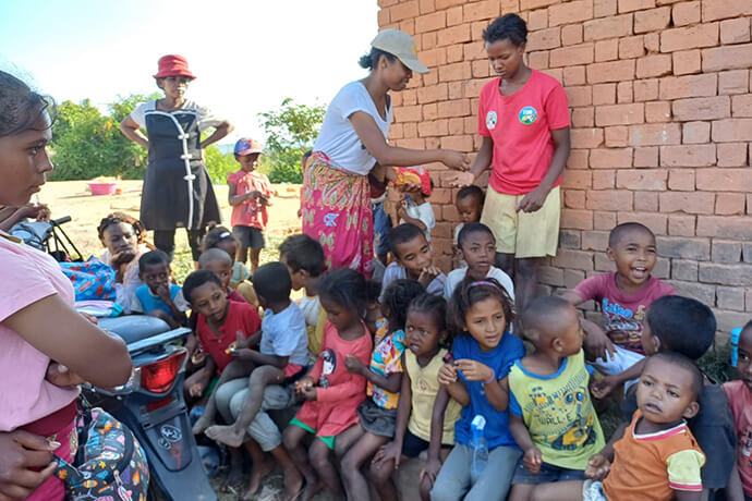 Líder dos jovens da Igreja de Ambodifasika compartilha doces com as crianças após um breve sermão durante seu passeio recreativo. Andohatanjona, foto de Esdras Rakotoarivony.
