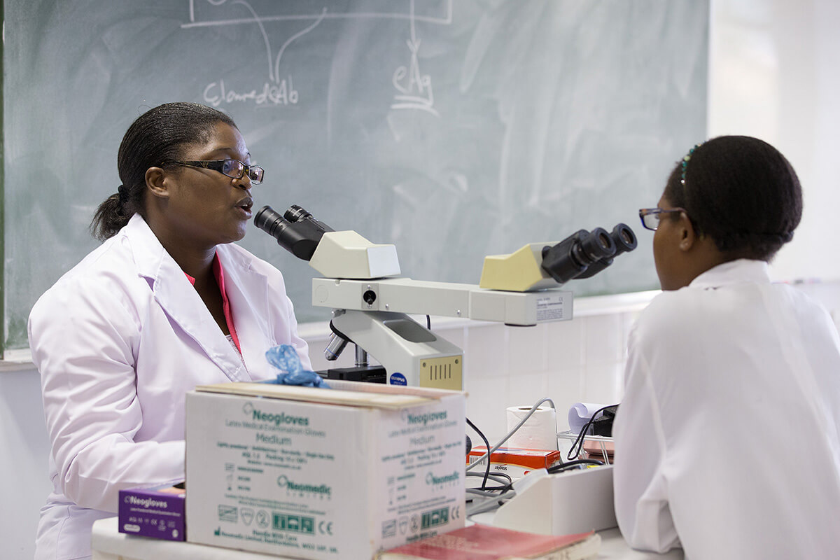 Un instructeur et un étudiant partagent un microscope d'enseignement à Africa University de Mutare, au Zimbabwe, en 2017. Photo de Mike DuBose, UM News.