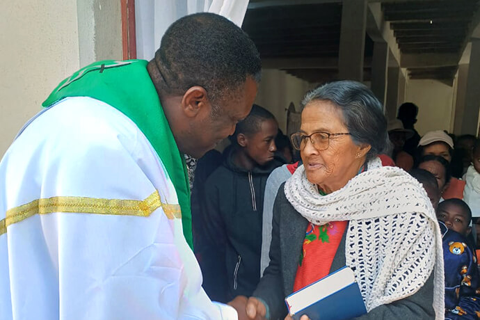 Le Révérend Éric Kalumba salue un membre de l'Église Méthodiste Unie d'Ambodifasika après le culte, à Ambodifasika, Madagascar. Le révérend Kalumba, missionnaire du United Methodist Board of Global Ministries (Conseil Méthodiste Uni des Ministères Mondiaux), est chargé d'implanter de nouvelles Églises Méthodistes Unies dans toute l'île. Photo par Esdras Rakotoarivony, UM News.